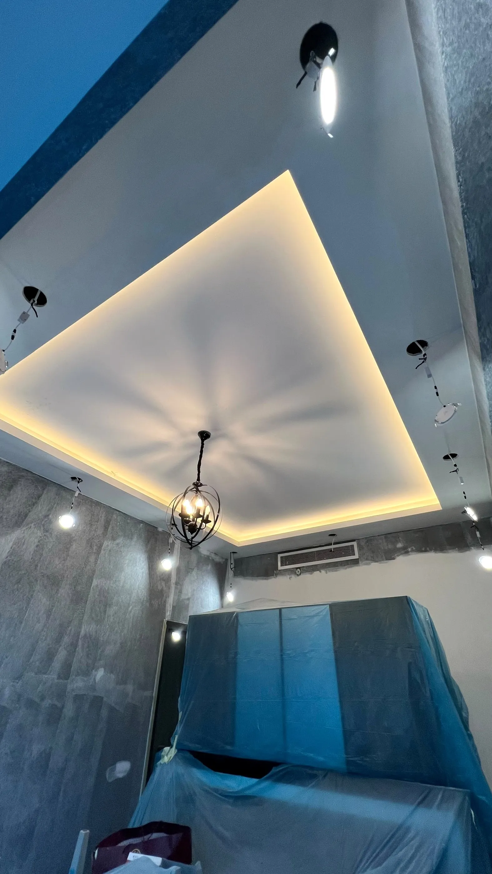 Gizli aydınlatmalı tavan göbeği, metal kafes avize ve beton efektli duvar