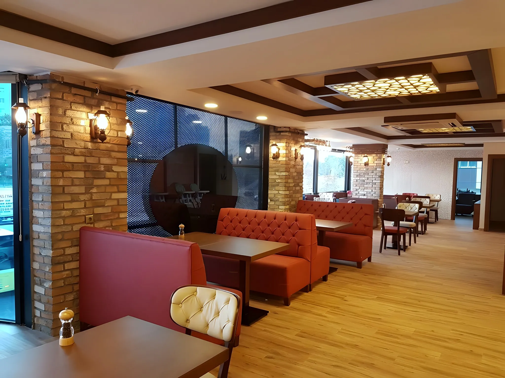 Pencere önünde kırmızı loca koltuklar ve ahşap masalar