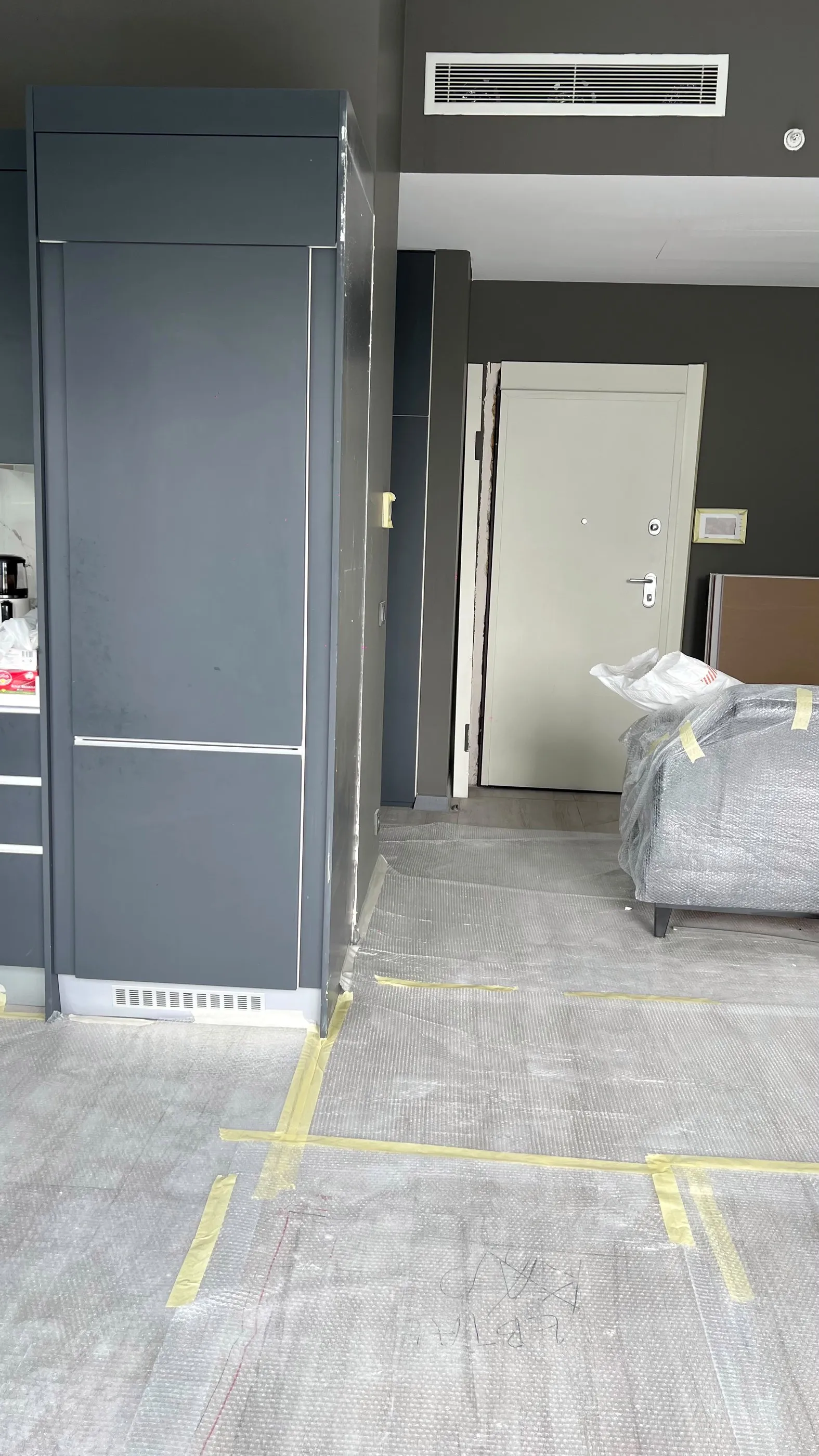 Antrasit boy dolapları ve giriş kapısı görünen açık mutfak