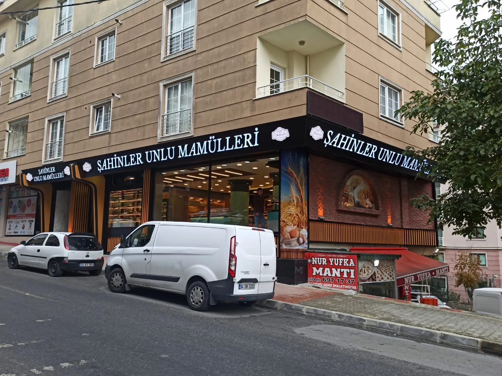 Uygulanan köşe cephe: siyah tabela bandı ve ışıklı Şahinler Unlu Mamülleri yazısı