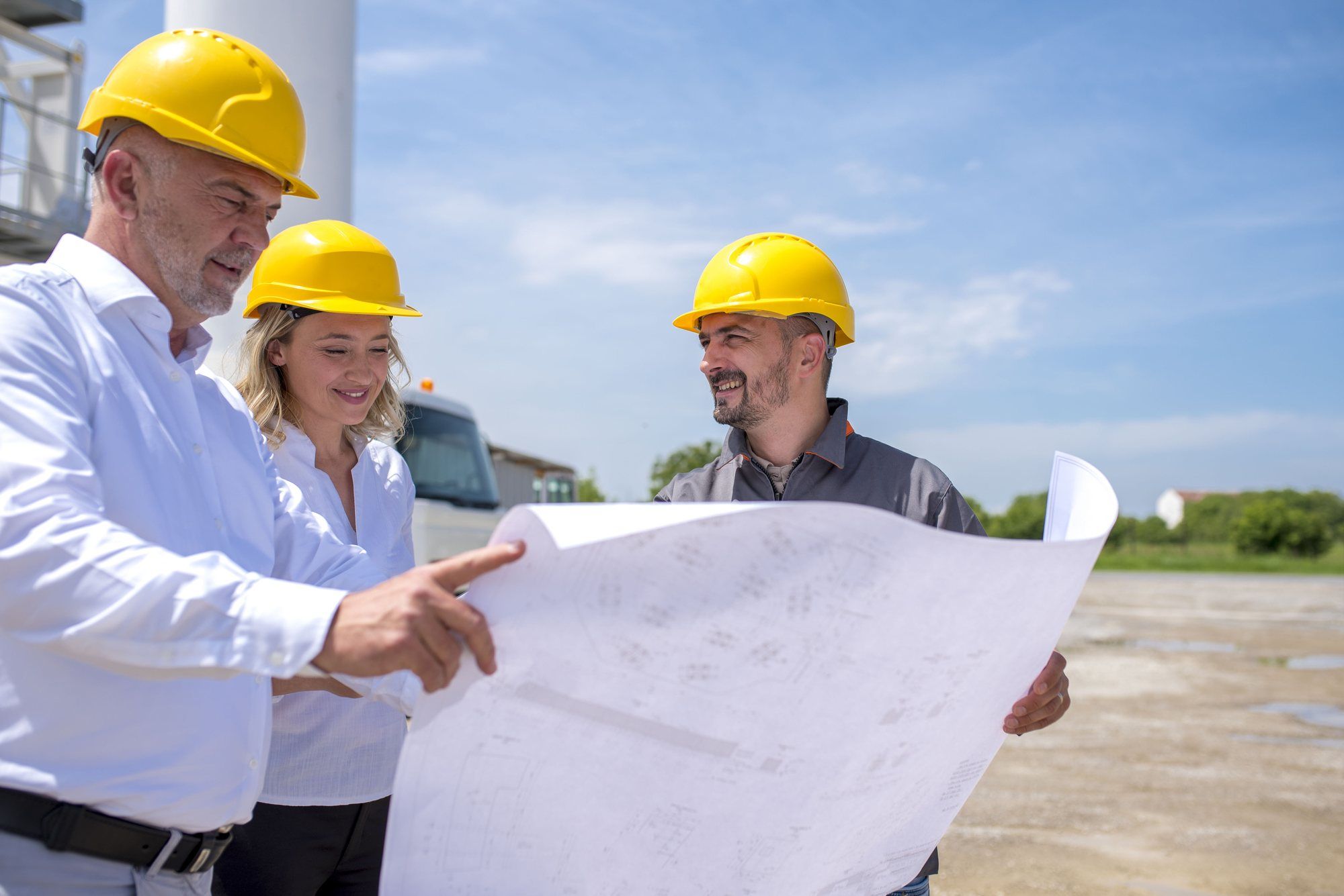 مهندسون يراجعون معا لوحة المشروع في موقع العمل